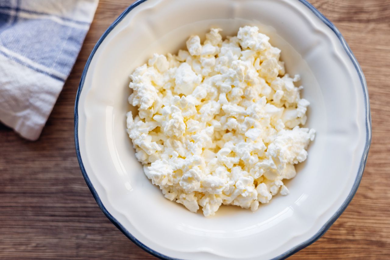 A bowl of cottage cheese on a wooden surface