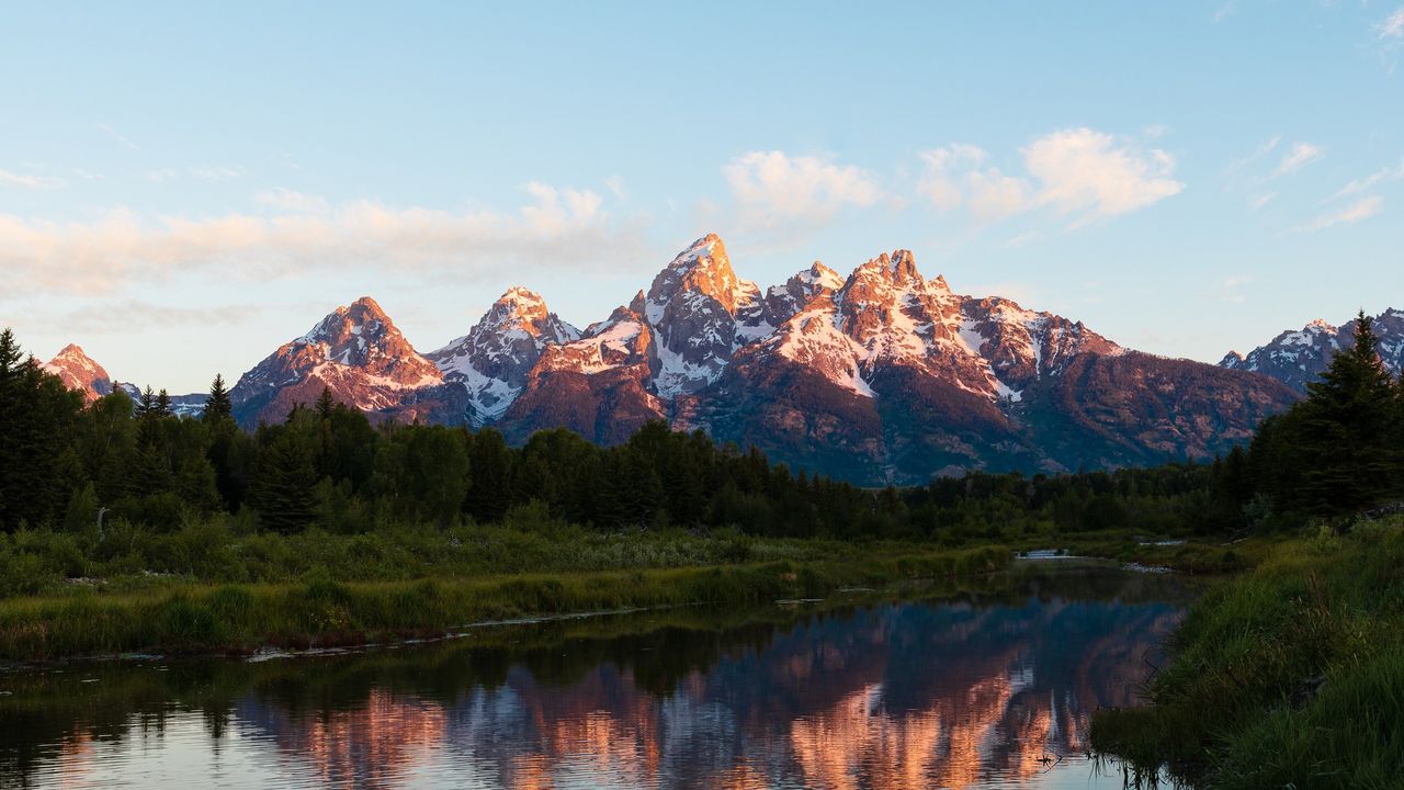 The Grand Tetons in the distance across a lake.