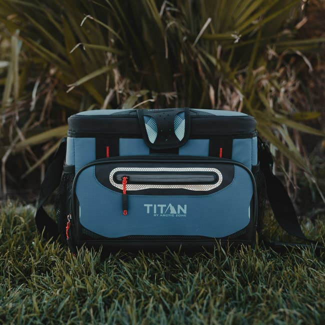 blue cooler bag with different compartments, zipper closures, and a shoulder strap