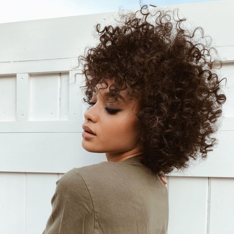 Curly shoulder length hair with bangs
