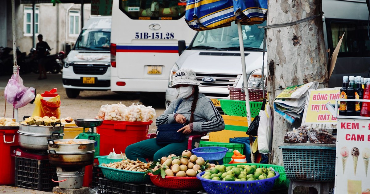 A vibrant street market scene featuring a fruit vendor in an urban setting in Vietnam.