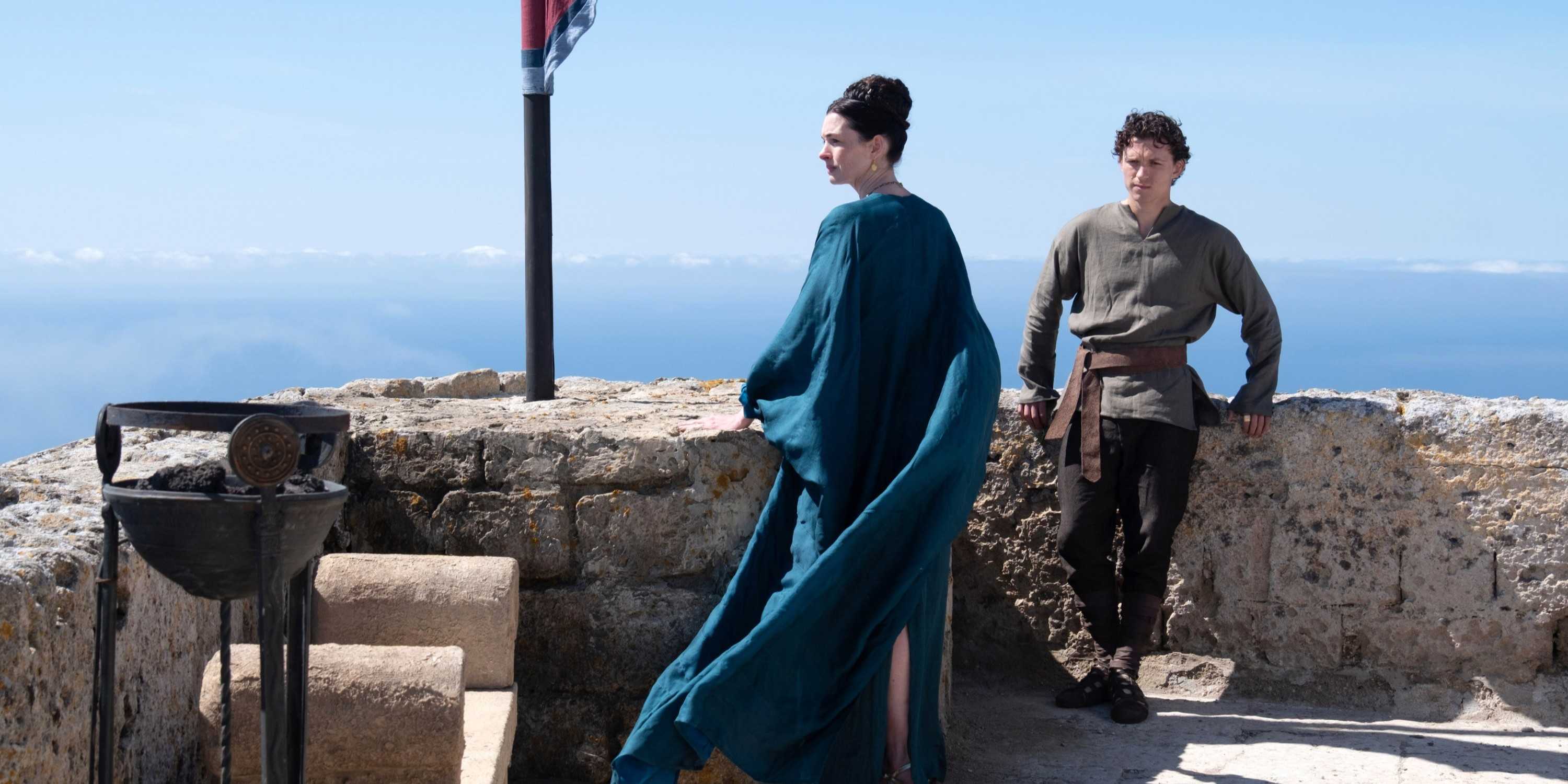 Penelope (Anne Hathaway) and Telemachus (Tom Holland) standing outside in The Odyssey.