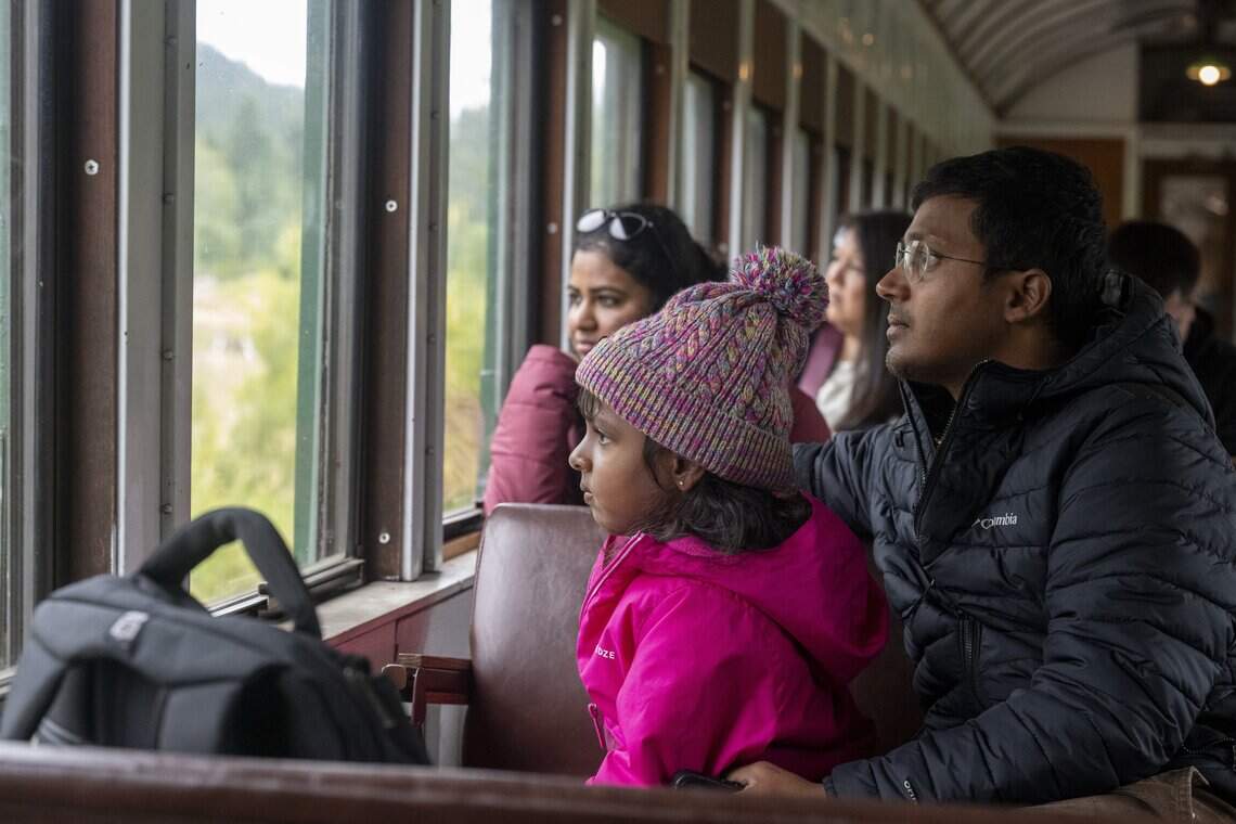 Poovitha Pranesh, left, Aadhini Pranesh, 5, and Pranesh Venkat, right, watch the scenery move by on the Mt. Rainier Scenic Railroad on Thursday, July 16, 2026, after departing from Elbe. The family from Austin, Texas, are visiting the Mount Rainier area.