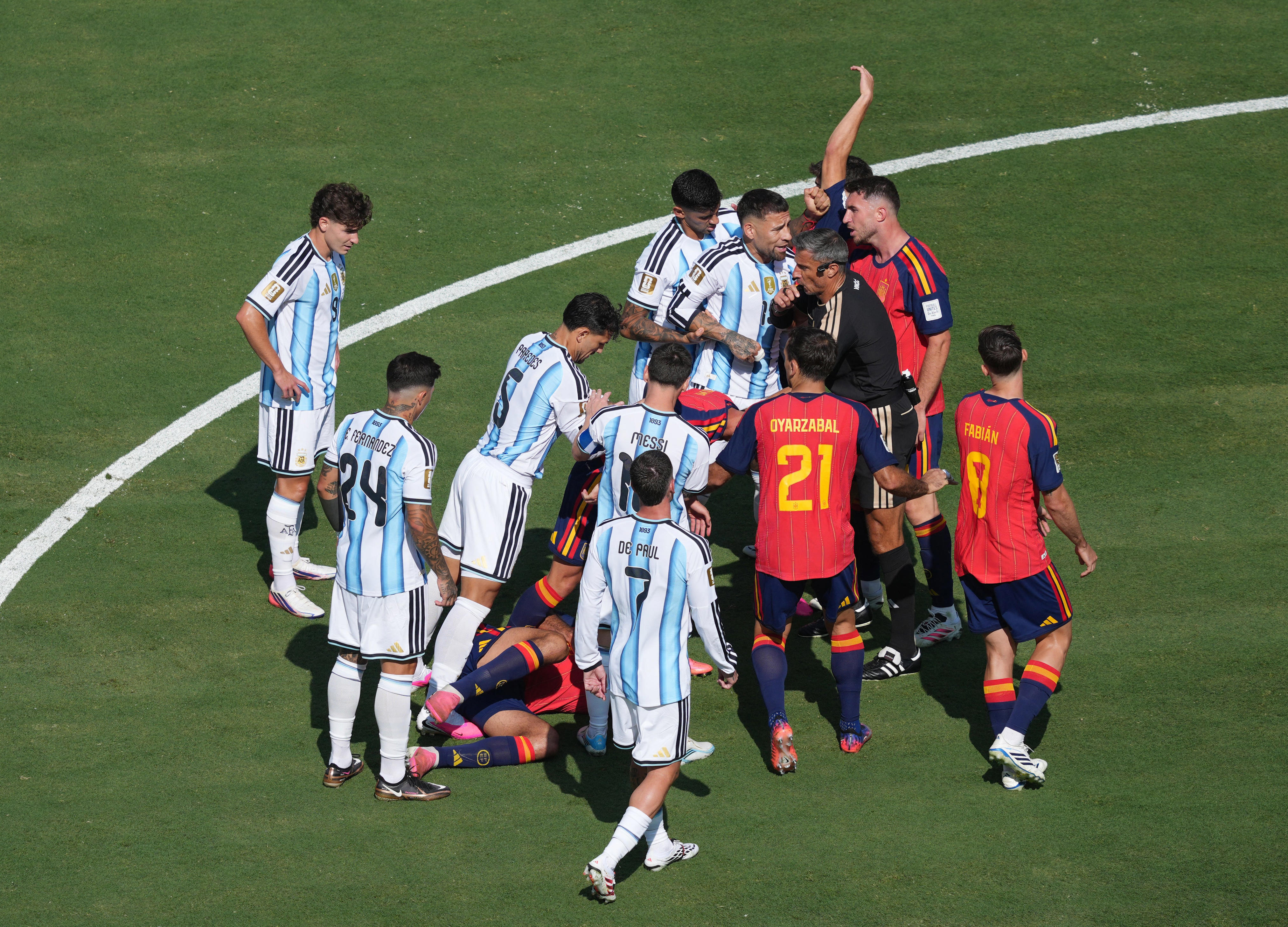 Argentina's Leandro Paredes and teammates Cristian Romero, Nicolas Otamendi and Lionel Messi confront referee Slavko Vincic next to Spain's Dani Olmo, Fabian Ruiz and Aymeric Laporte after Paredes' foul during the World Cup final in New Jersey on July 19, 2026.