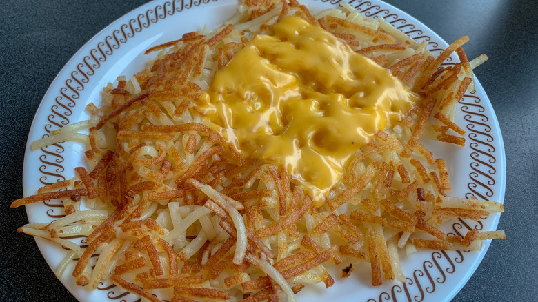Scattered hash browns from Waffle House topped with cheese