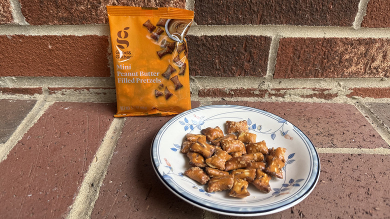 Small bag of Good & Gather peanut butter-filled pretzels on brick surface, with some displayed on adjacent plate