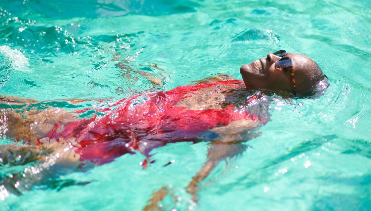 A woman in a pool swimming to improve her heart health