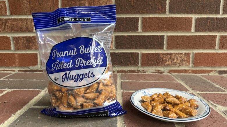 Bag of Trader Joe's peanut butter-filled pretzels on brick surface, with some displayed on adjacent plate