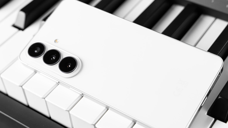 A white Samsung Galaxy S26 on a piano keybed