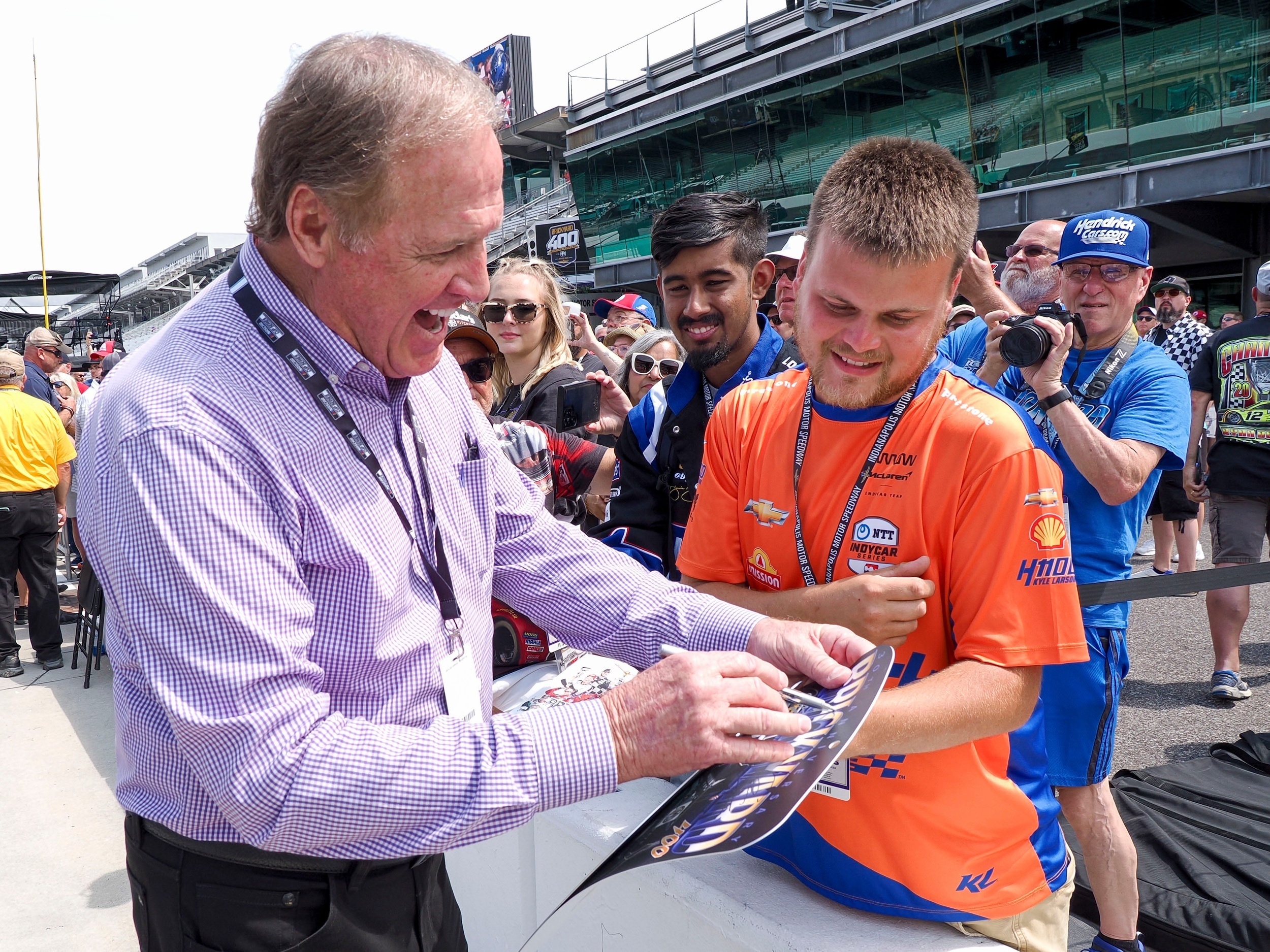 Former NASCAR driver Rusty Wallace signs an autograph in 2024.