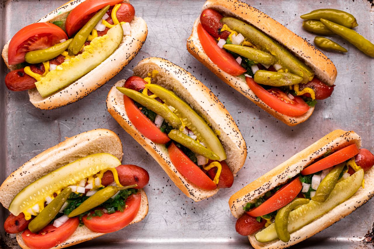 Overhead view of a sheet pan with Chicago-style hot dogs on it.