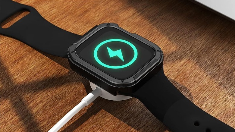 Charging sign on a smartwatch connected to a charger.