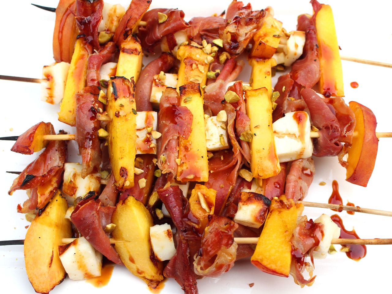 overhead closeup of skewers of grilled peach, halloumi, prosciutto