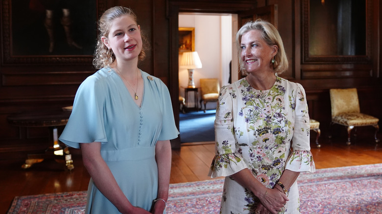 Lady Louise wears a curly lob and blue dress pictured with Duchess Sophie in a white floral dress