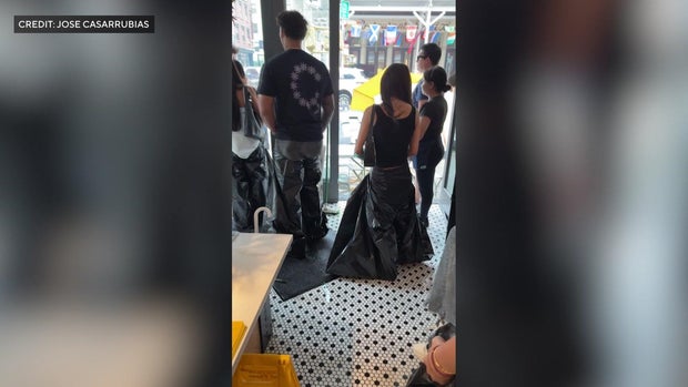 People standing in garbage bags inside a restaurant
