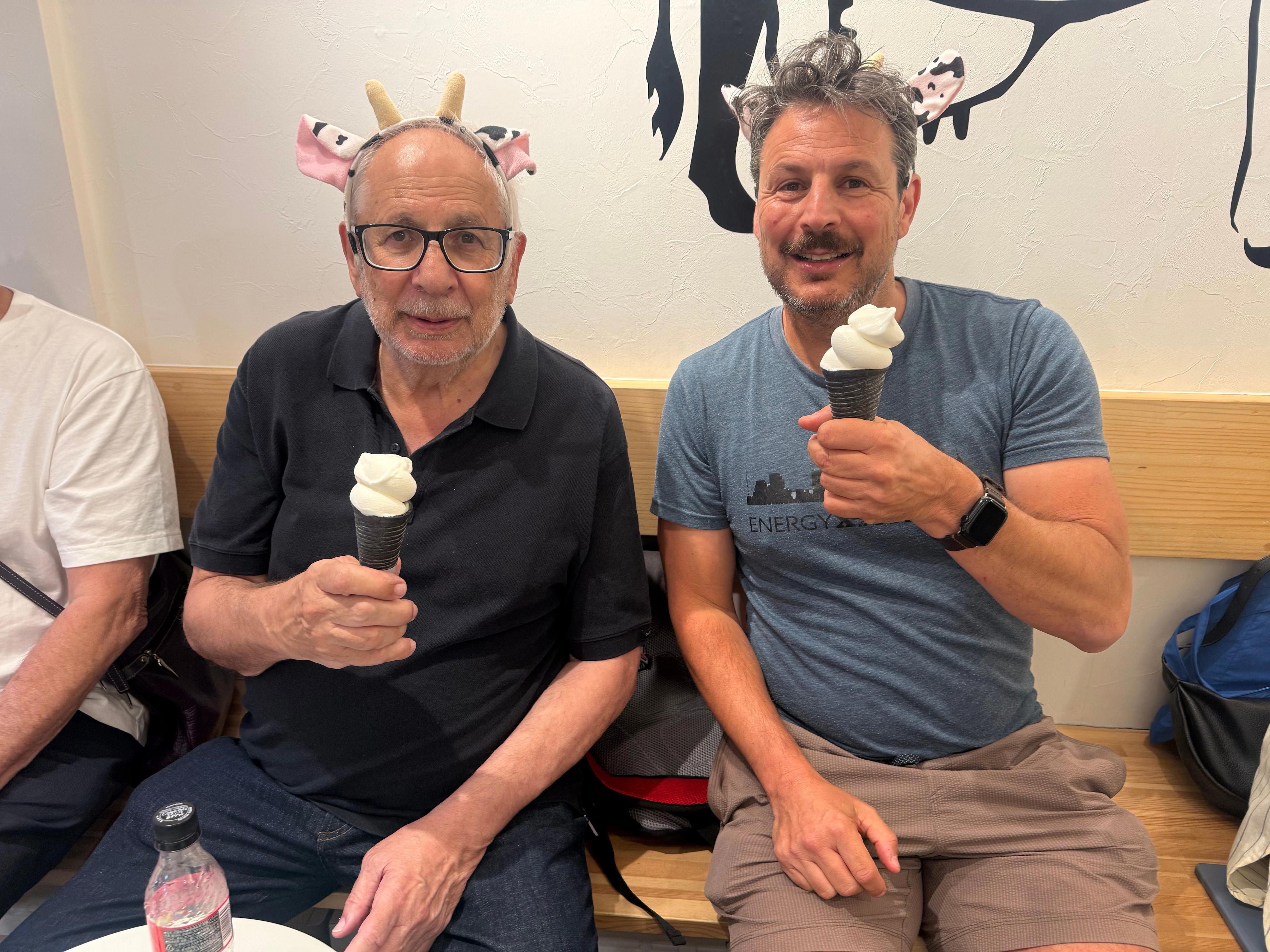 Author Ash Jurberg holding ice cream, smiling with his dad who is holding ice cream