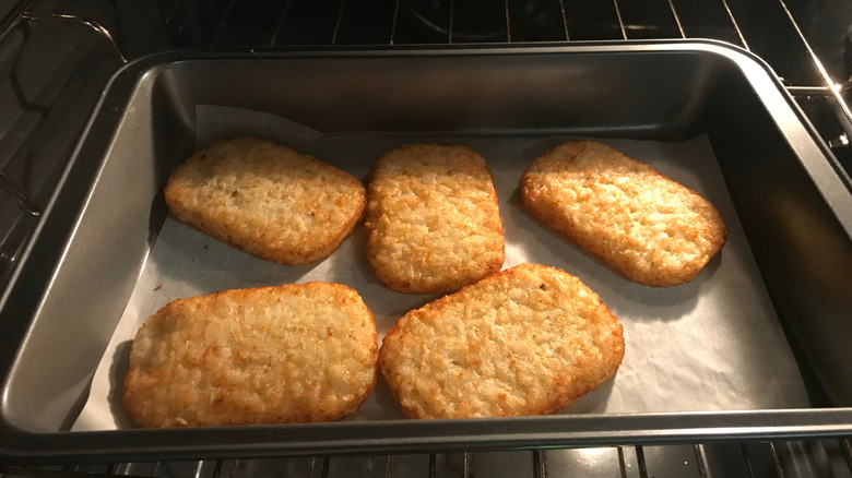 Hash brown patties on an oven tray.