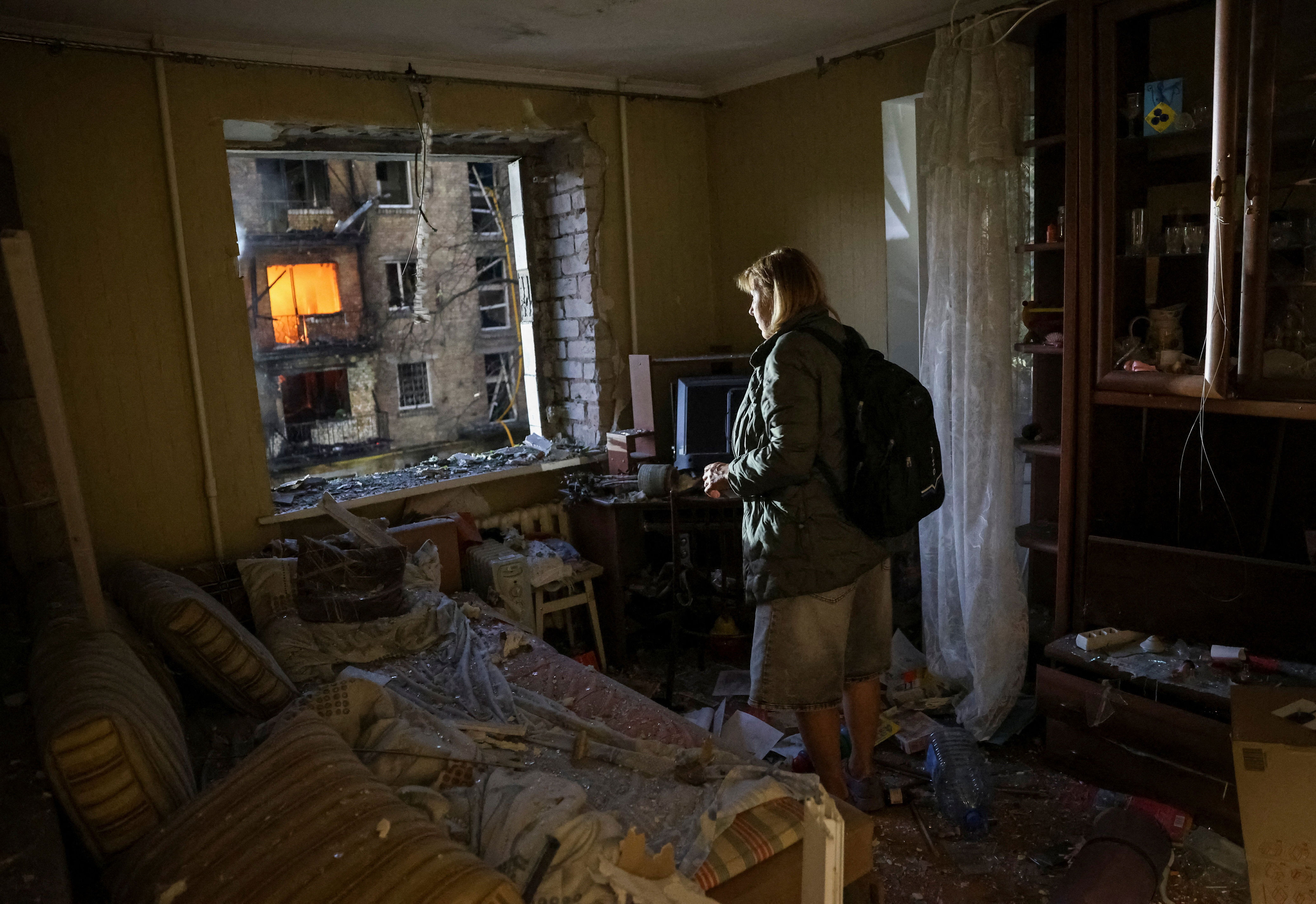 A woman inspects her home after a Russian missile strike (Reuters)