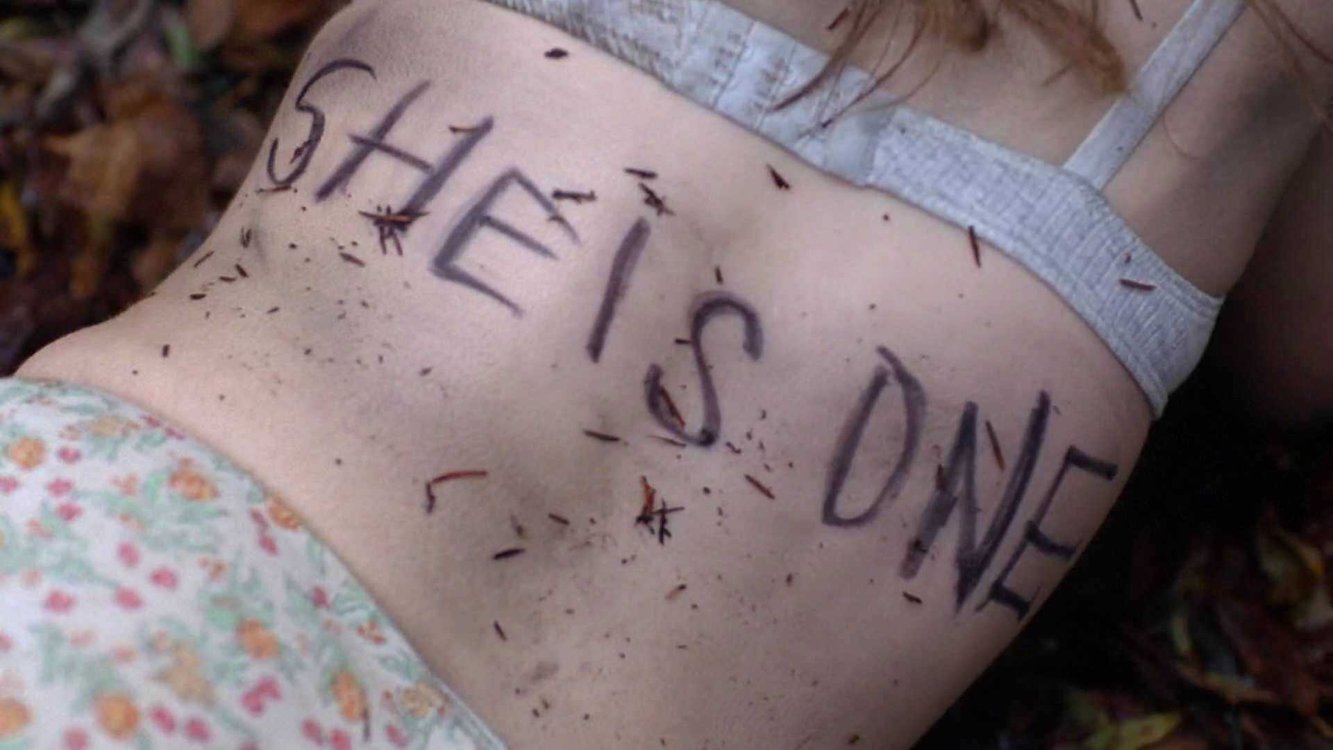 A woman with She Is One written on her back in X-Files Red Museum