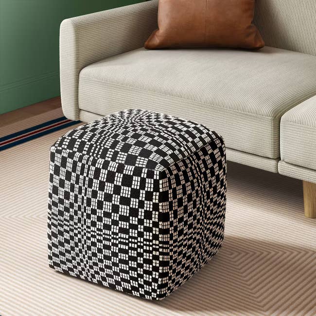 Checkered ottoman in a modern living room with a beige sofa