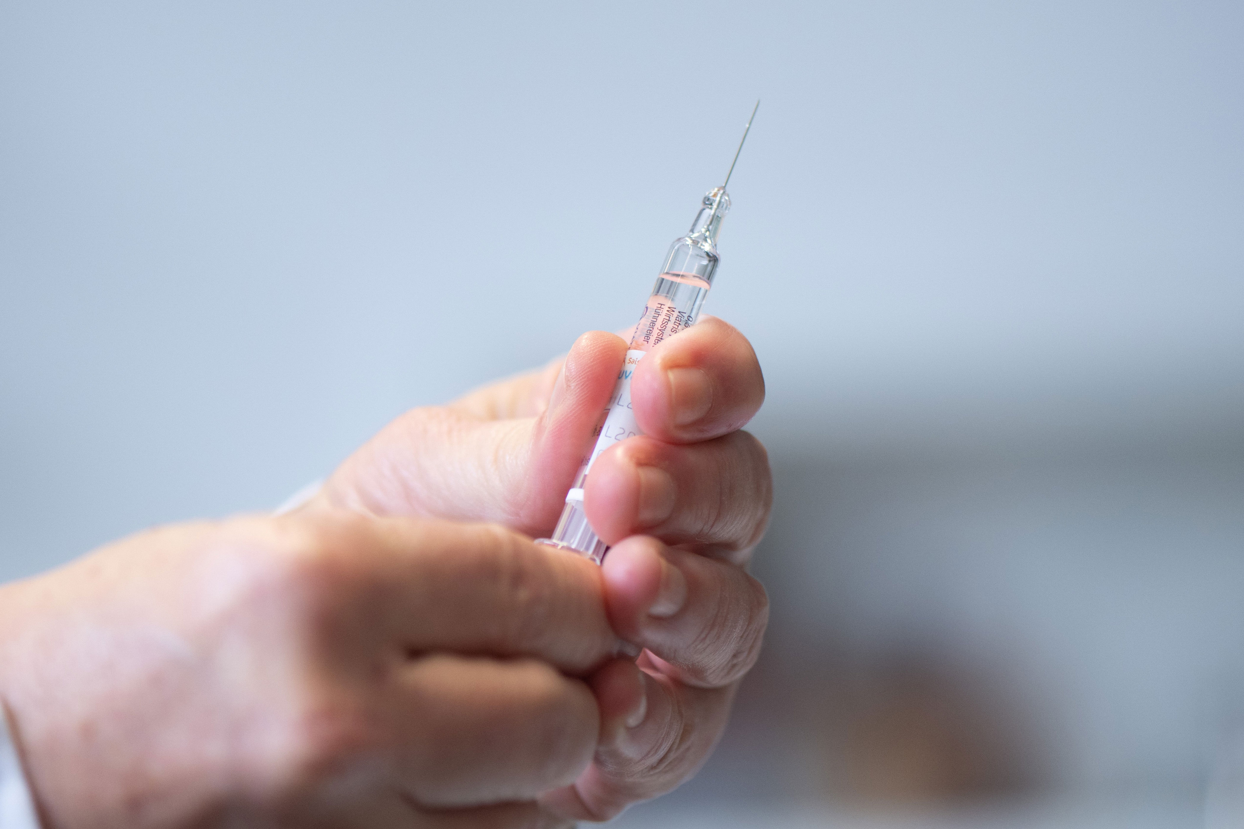 Hands holding a syringe, ready to administer an injection