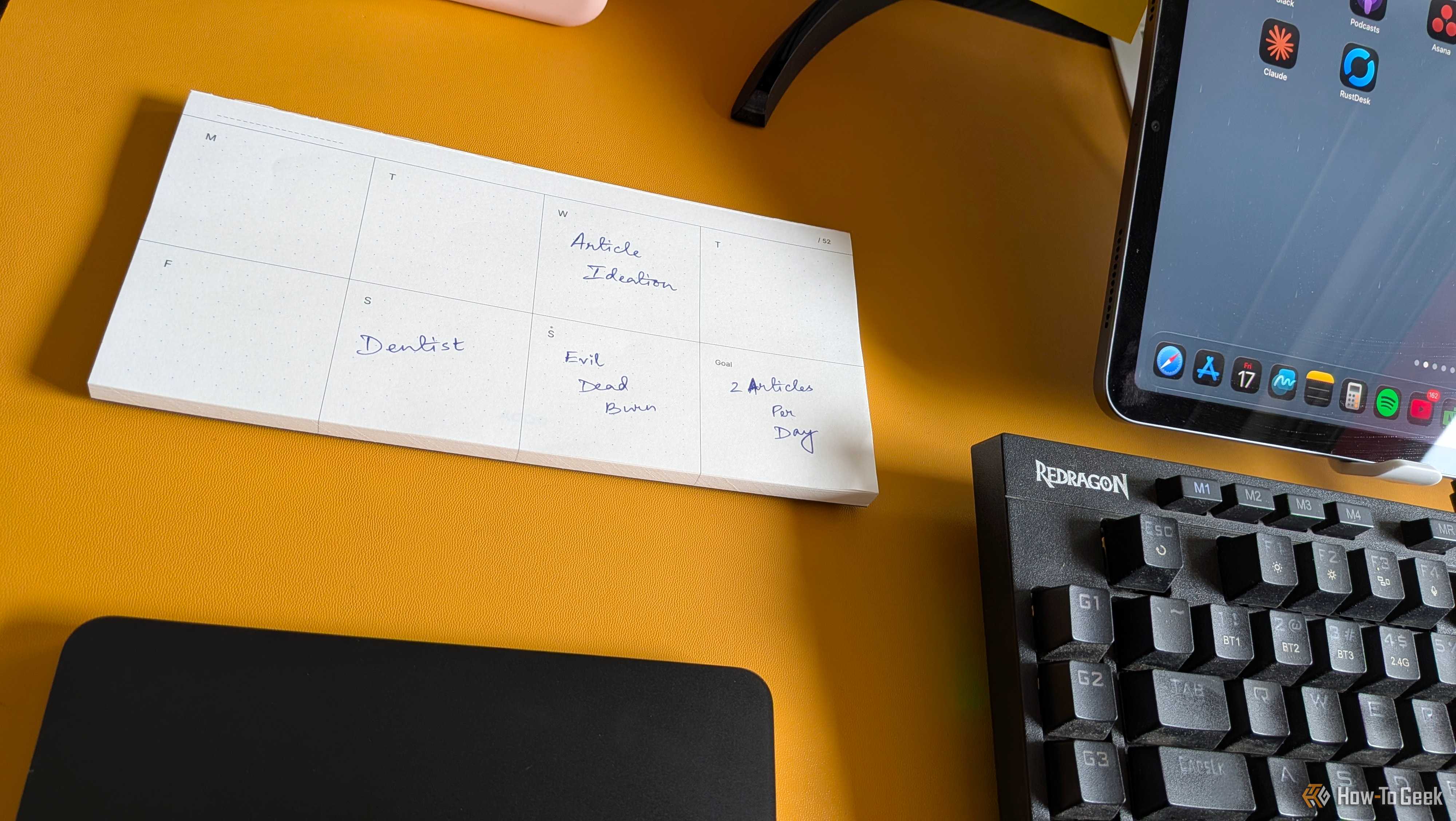 Weekly planner pad filled in with Article Ideation, Dentist, Evil Dead Burn, and a 2 Articles Per Day goal.