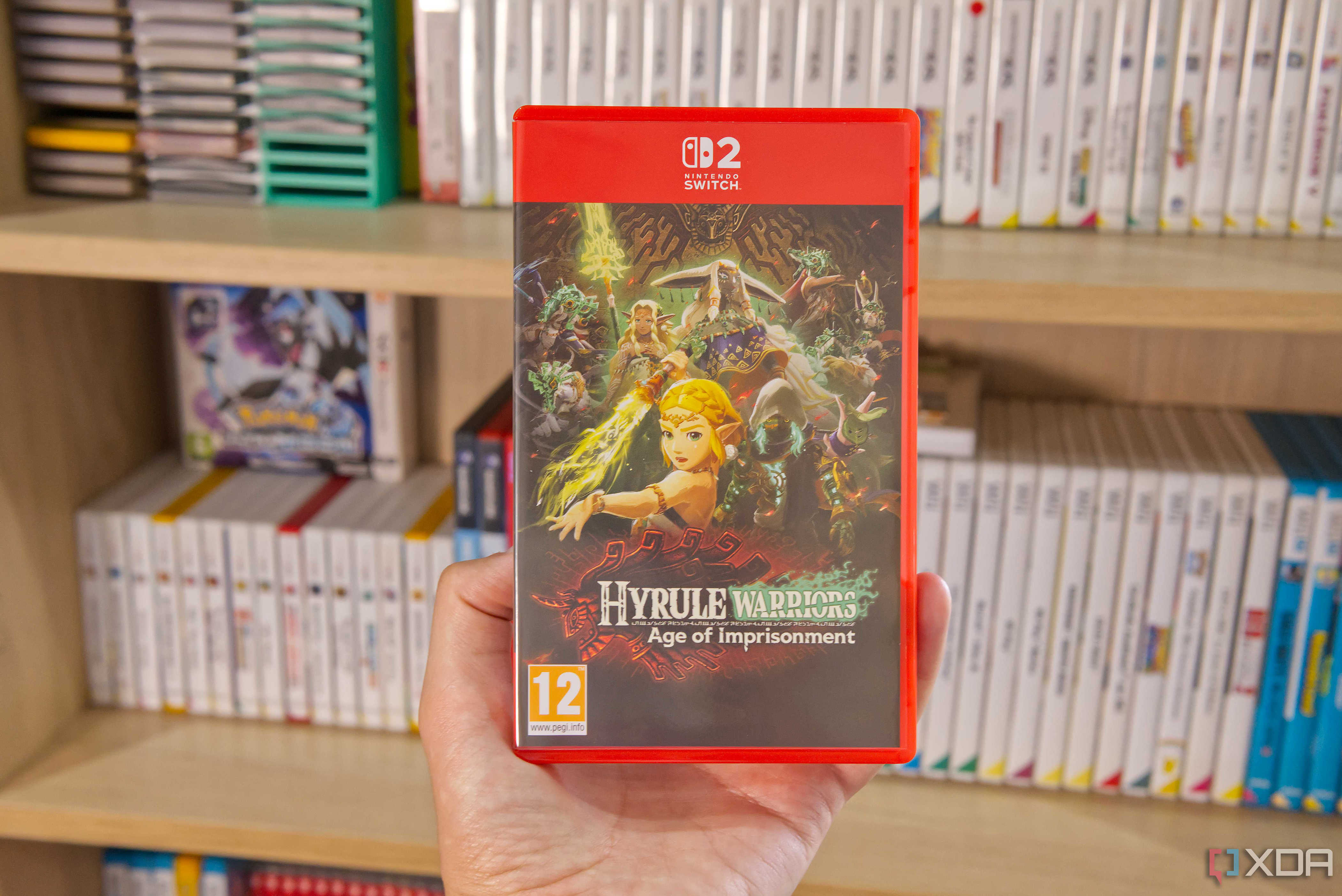 A game case for Hyrule Warriors: Age of Imprisonment on the Nintendo Switch 2, with shelves in the background showing games for the Game Boy, Nintendo DS, 3DS, Wii, Wii U, and Nintendo Switch