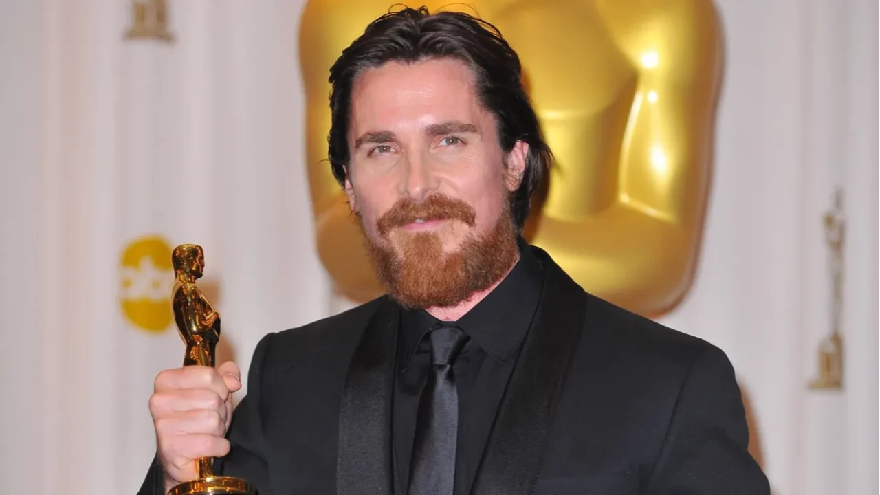 Christian Bale holding an Oscar Award.