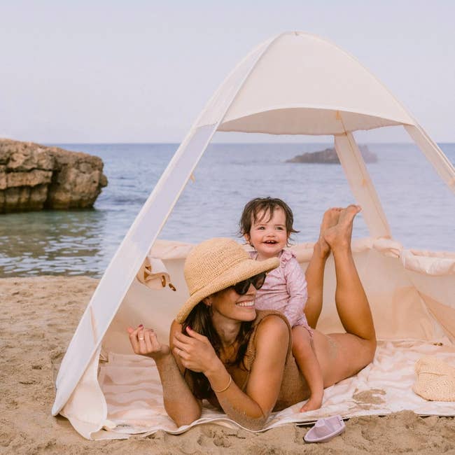 a model sits in tent with toddler