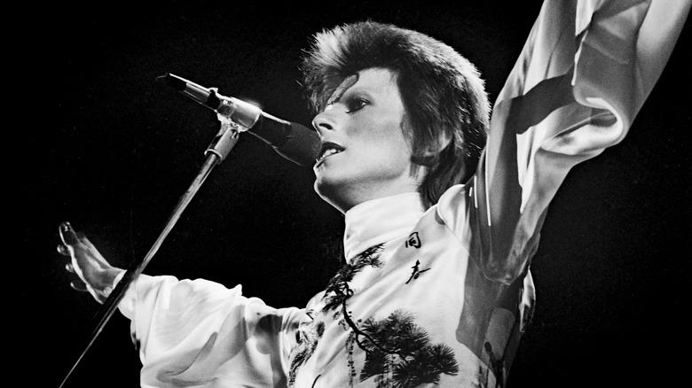 David Bowie in costume and makeup performing on stage