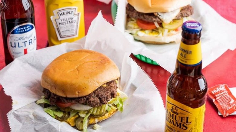 Firehouse burger on paper with bottles of beer and mustard