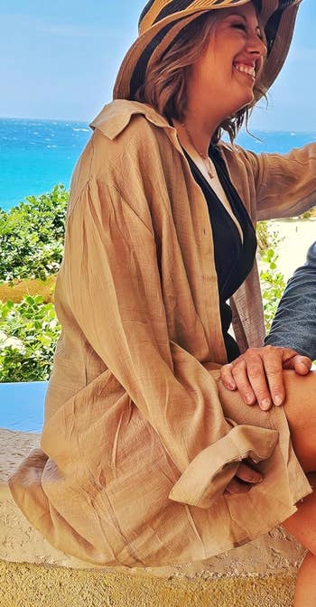 Another reviewer in apricot cover up and hat with beach in background
