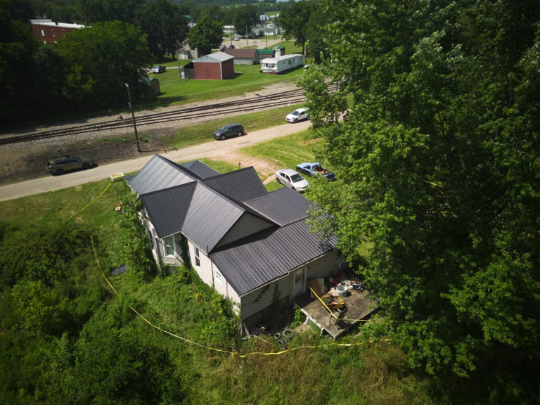 Police tape surrounds a home where authorities say they removed 16 children and arrested four adults in Hamden, Ohio, Wednesday, July 1, 2026. (AP Photo/Carolyn Kaster)