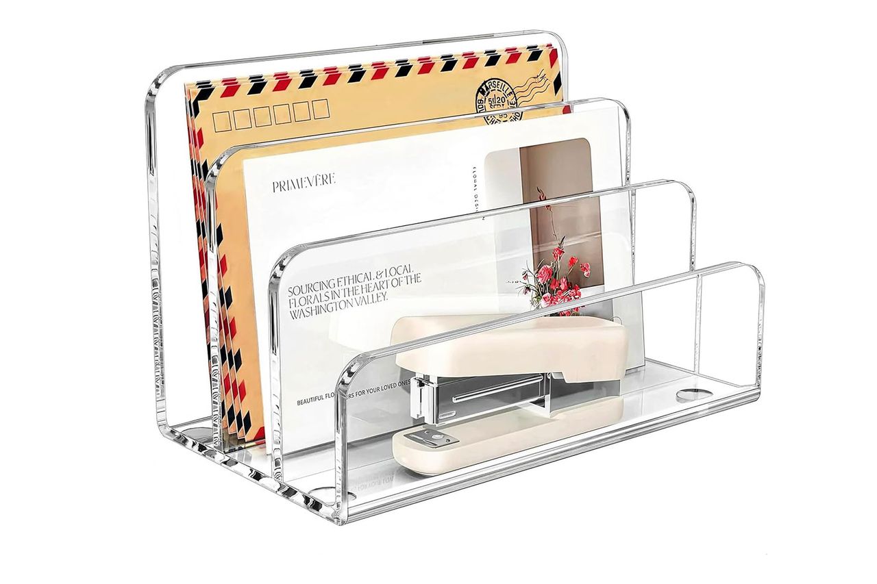 A clear desk organizer holding mail and a stapler