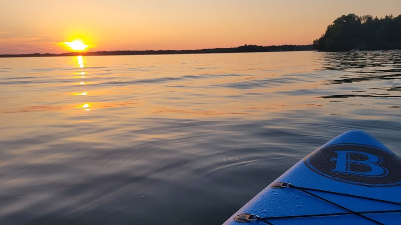 Sunset at Lake Simcoe, with a reflective water surface, as seen from a blue kayak, McRae Point Provincial Park, Ontario, Canada