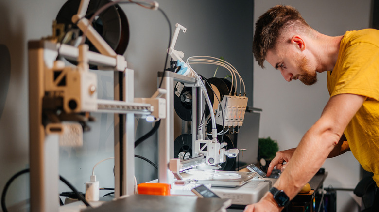 Man programming 3D printer