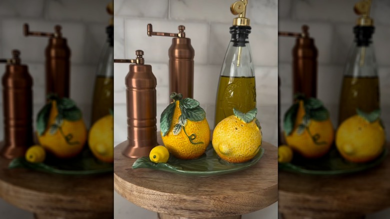 Lemon shaped salt and pepper shakers with olive oil and grinders on pedestal