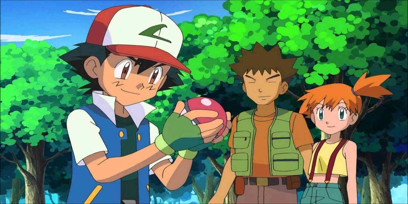 Ash smiles looking down at a Pokeball while Brock and Misty stand behind him in Pokemon.