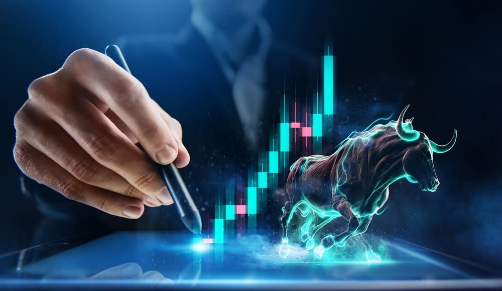 A close-up of a hand holding a black stylus, interacting with a glowing blue digital tablet screen. In the background, a vibrant, neon-lit bull leaps forward, accompanied by a dynamic candlestick chart showing an upward trend with blue and pink bars against a dark, futuristic background.
