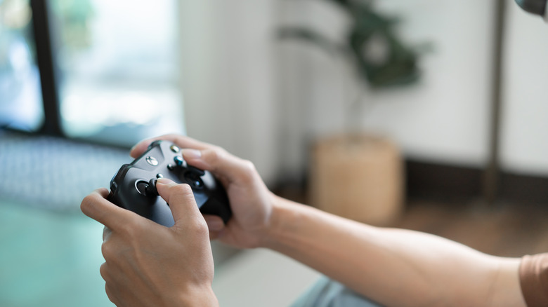 A person using an Xbox controller to game.