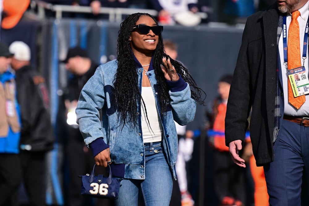 Nov 24, 2024; Chicago, Illinois, USA; United States gymnast Simone Biles walks on the sideline before the game between the Chicago Bears and Minnesota Vikings at Soldier Field. Mandatory Credit: Daniel Bartel-Imagn Images