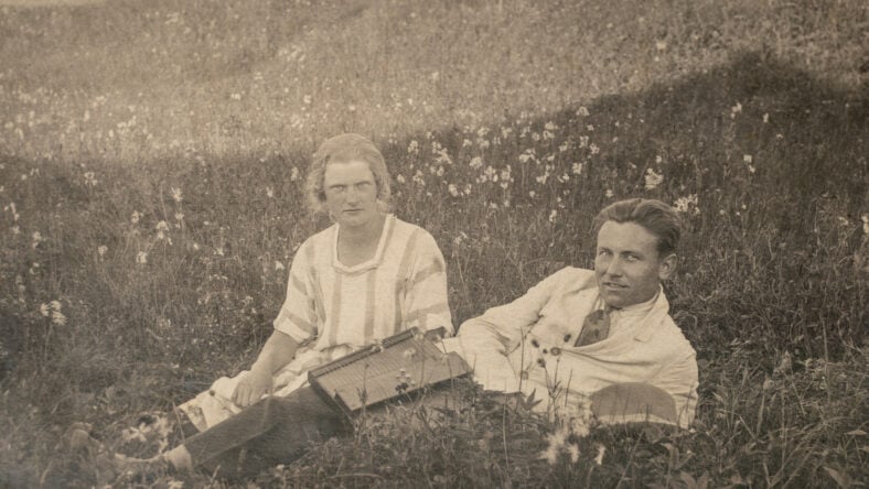 Married couple relaxing at field during picnic. Vintage Edwardian - Art deco era photo