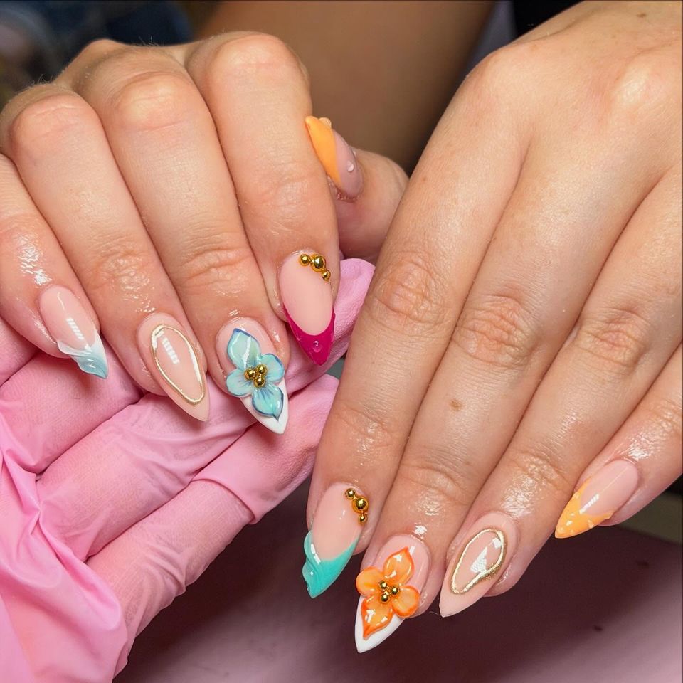 Closeup of hands showing colorful manicured nails with decorative flower designs