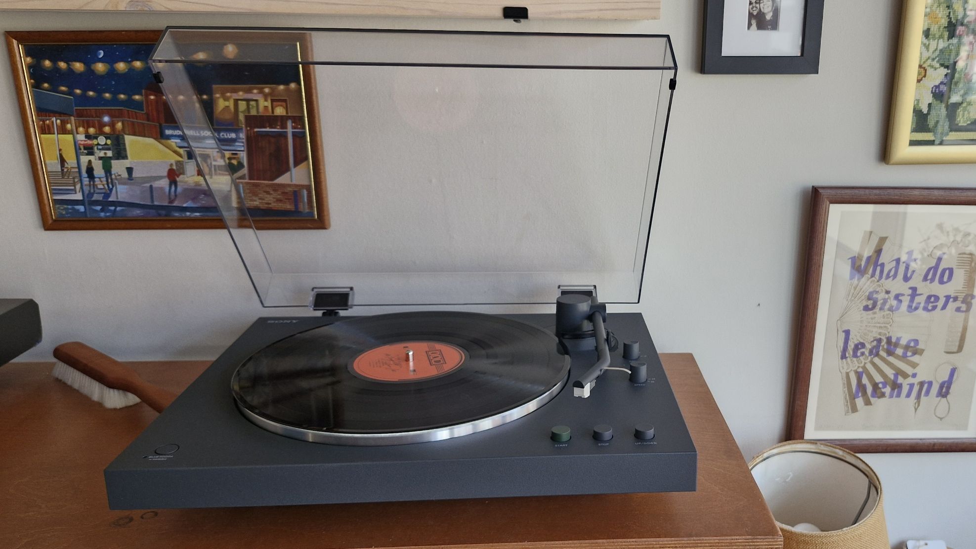The Sony PS-LX3BT turntable, with the dust cover open, on a wooden surface.