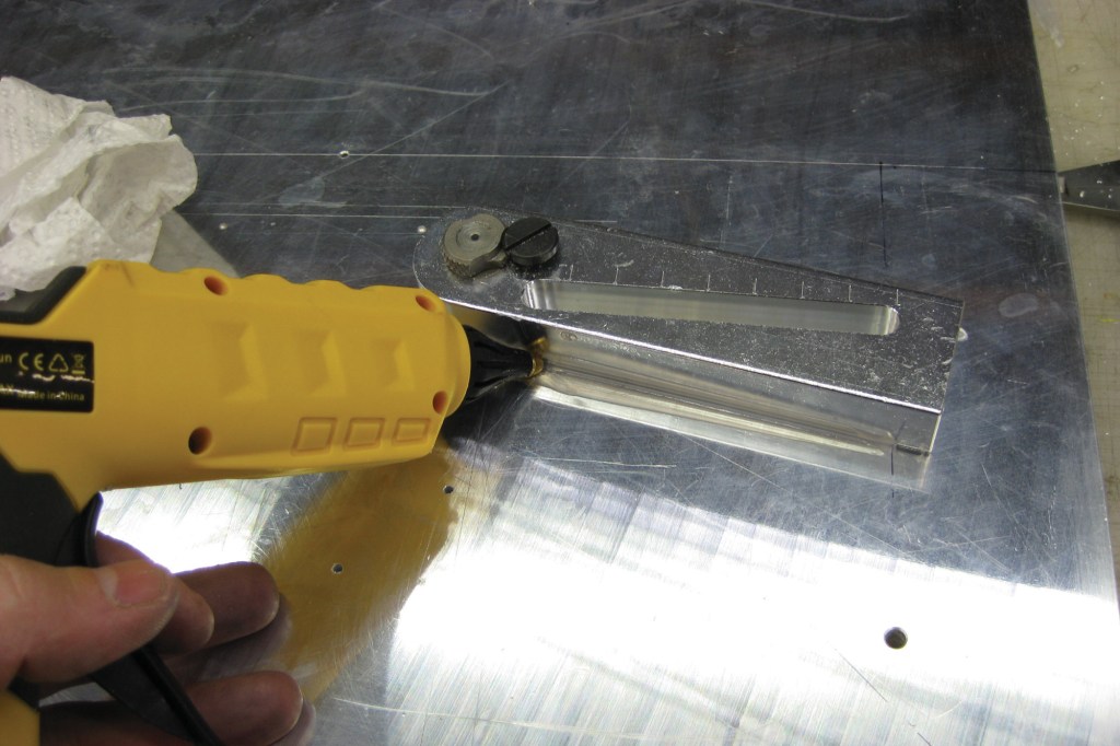 Using a glue gun to affix a drill guide where a clamp doesn't reach.