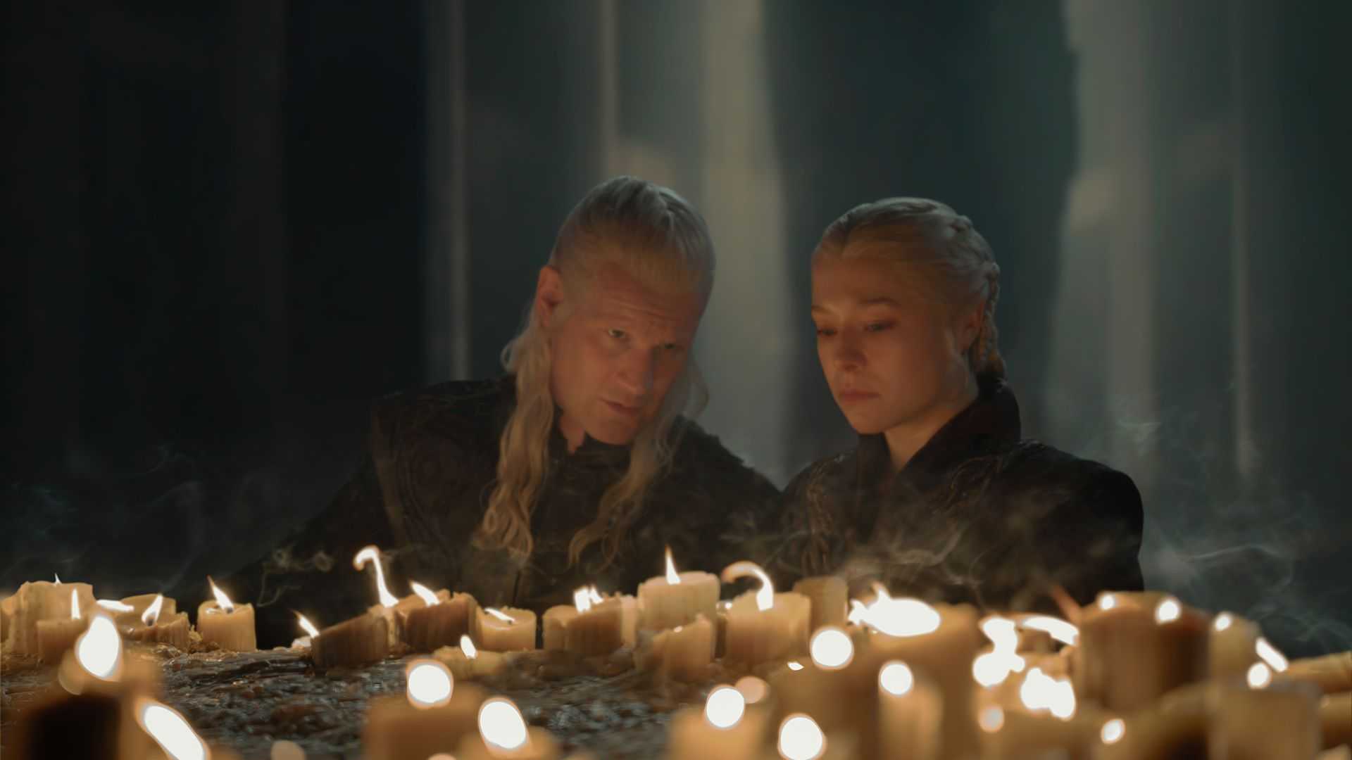 Daemon and Rhaenyra crouched before candles in House of the Dragon