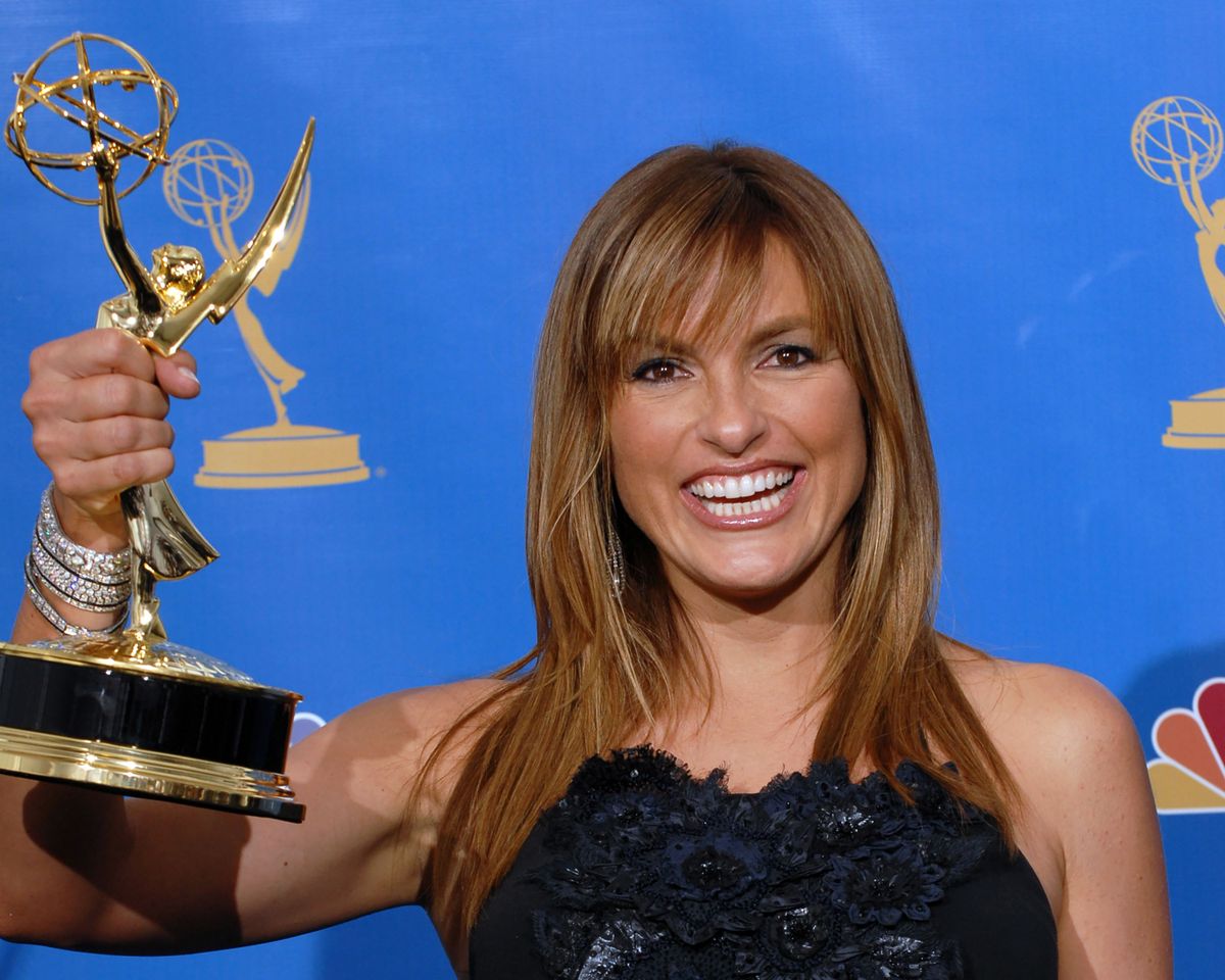 Mariska Hargitay holding an Emmy award smiling at the camera