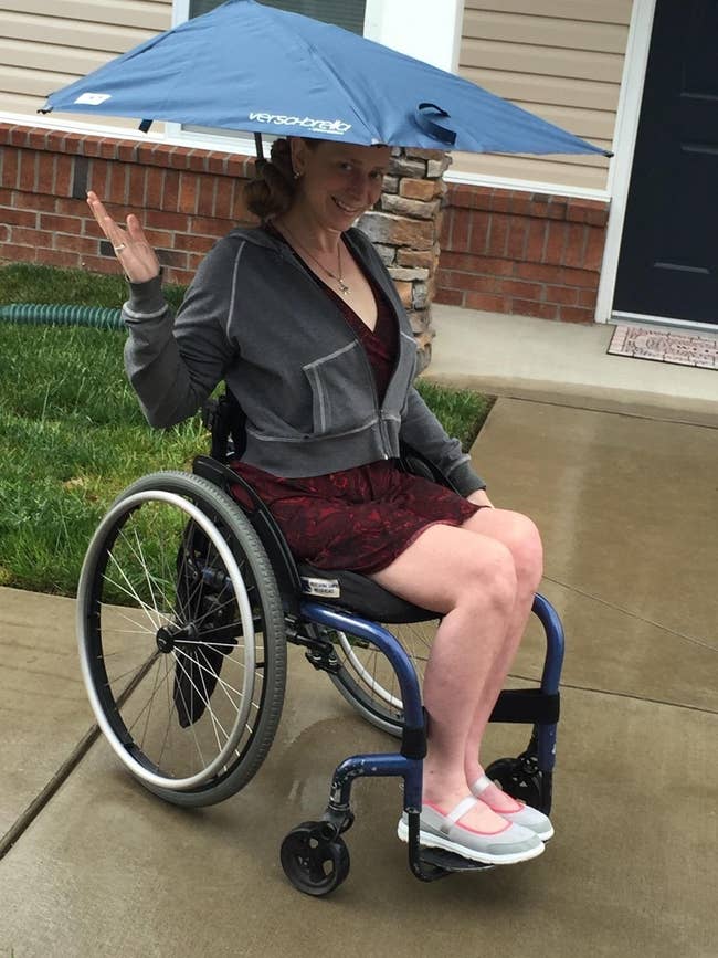 reviewer shows off umbrella that is clipped to their wheelchair