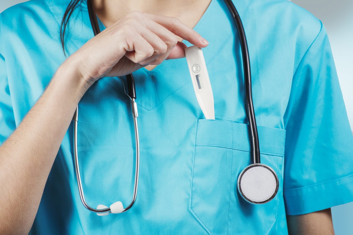 woman nurse or doctor close up while putting thermometer inside chest pocket