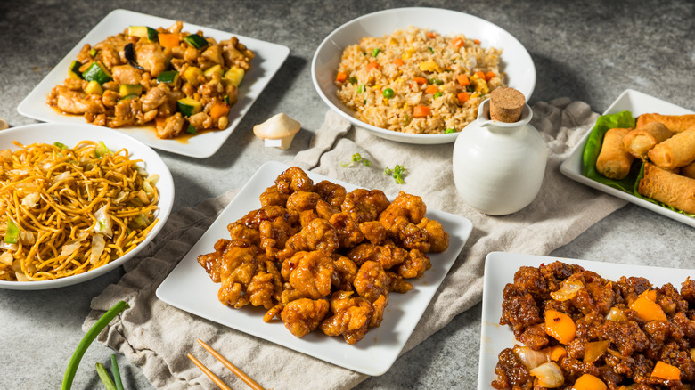 variety of Chinese menu items on a gray table